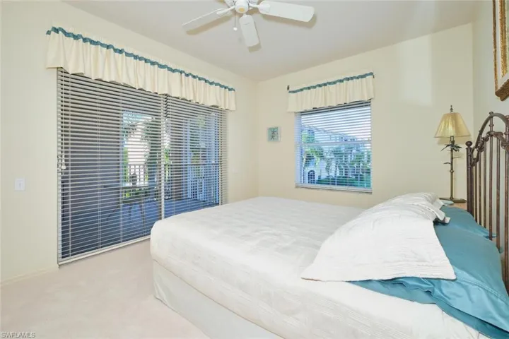 Bedroom with access to outside, carpet flooring, and a ceiling fan