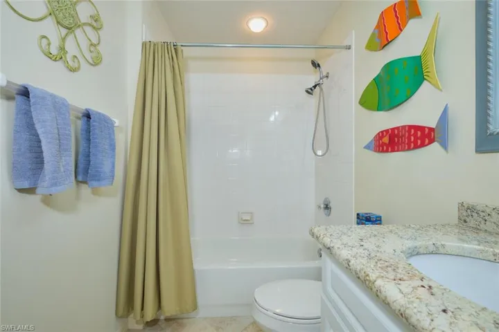 Bathroom with vanity, shower / bath combination with curtain, and light tile patterned floors