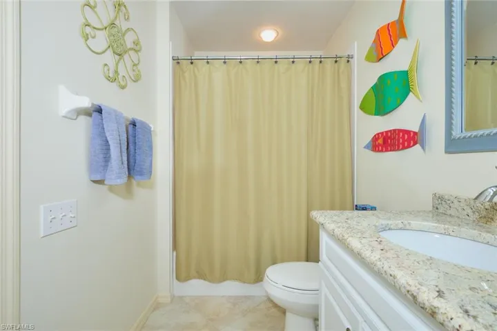 Bathroom with vanity, light tile patterned flooring, and shower / bath combo with shower curtain