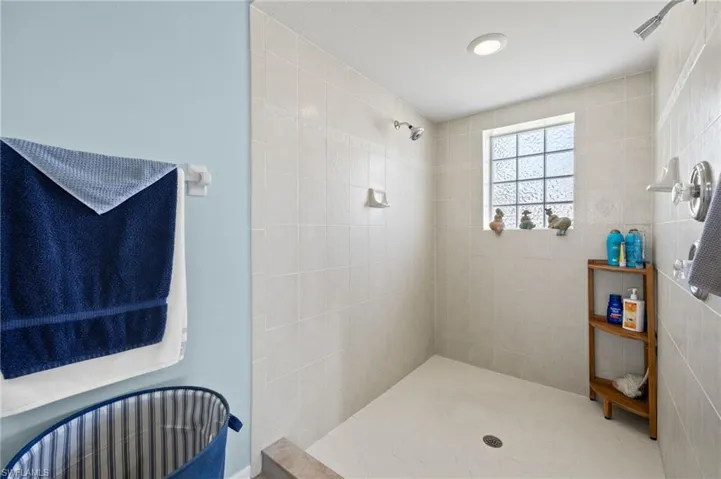 Primary bath has a huge tiled shower with dual shower heads and a window for natural light. Not pictured is a separate water closet with a pocket door.