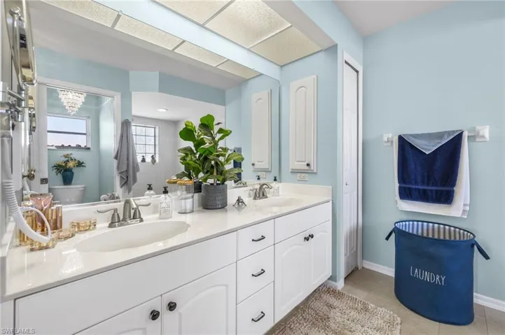 Primary bathroom features dual sinks and a linen closet.