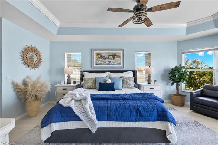 Primary bedroom is light and bright with tray ceiling