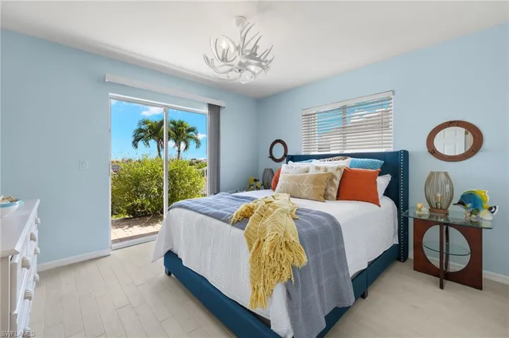The first of two guest rooms has brand new plank tile flooring and walks out to the pool through a sliding door.
