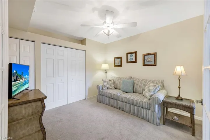 Carpeted living room with ceiling fan