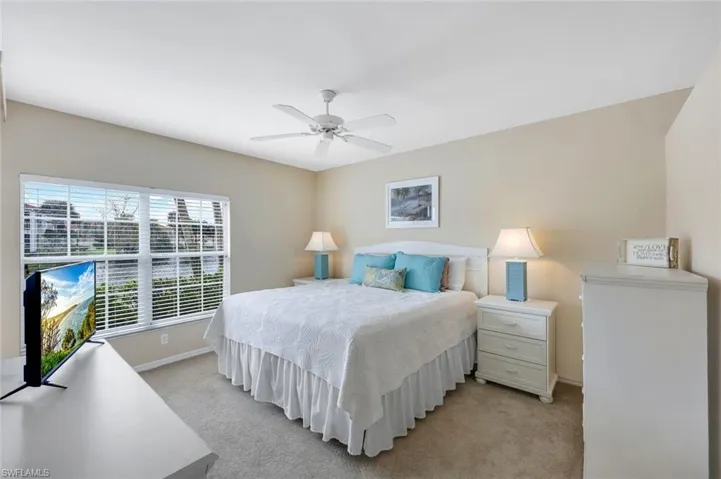 Carpeted bedroom featuring ceiling fan
