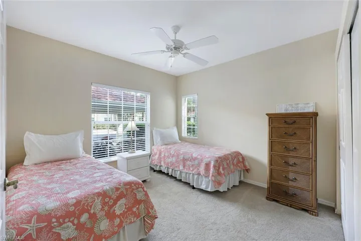 Bedroom featuring ceiling fan, multiple windows, a closet, and light colored carpet