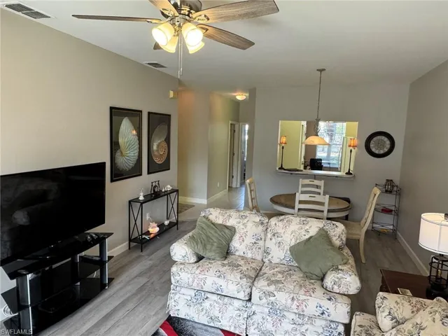 Living room with ceiling fan and light hardwood / wood-style floors