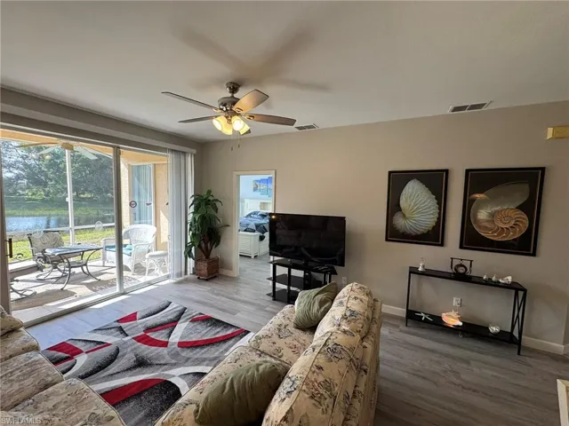 Living room with hardwood / wood-style floors and ceiling fan
