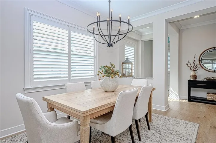 Dining room featuring an inviting chandelier, crown molding, and light hardwood / wood-style flooring