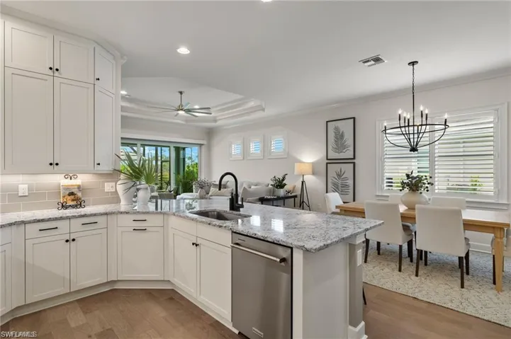Kitchen with white cabinetry, sink, light hardwood / wood-style flooring, and stainless steel dishwasher