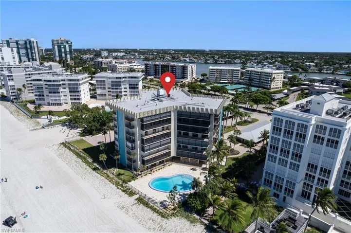 Aerial of the building and pool from the beach.