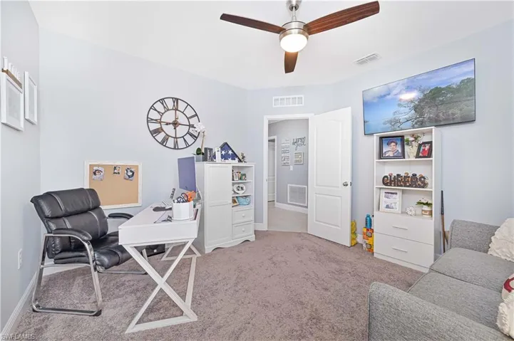 Office space with light carpet and a ceiling fan