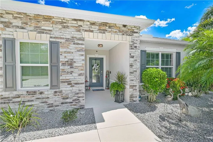 Entrance to property with stone siding and stucco siding