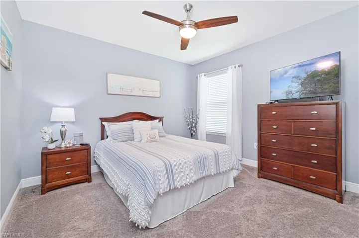 Bedroom featuring light carpet and a ceiling fan