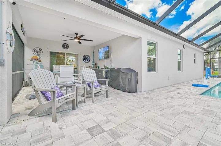 View of patio with a sunroom, area for grilling, glass enclosure, ceiling fan, and an outdoor pool