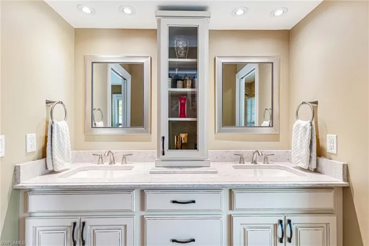 Dual vanity with white cabinetry, light-colored countertop, and brushed nickel fixtures - Virtually Edited Image