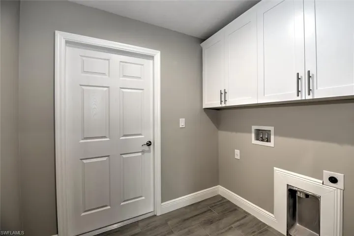 Laundry area featuring hookup for a washing machine, hookup for an electric dryer, and cabinets