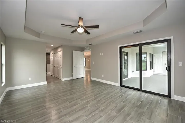 Empty room featuring ceiling fan and a tray ceiling