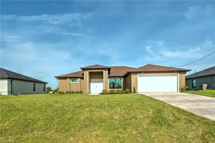 View of front of house featuring a garage and a front lawn