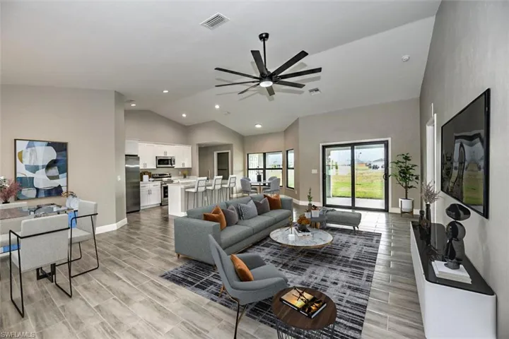 Living room with lofted ceiling and ceiling fan