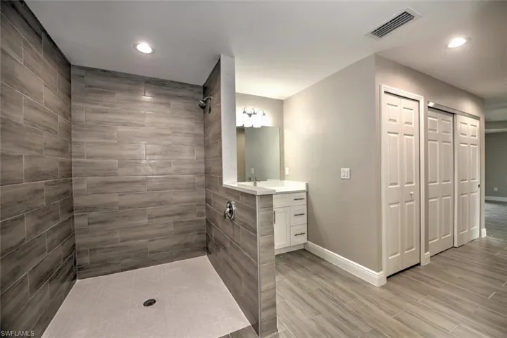 Bathroom with vanity and a tile shower