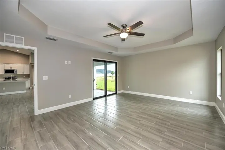Unfurnished room featuring ceiling fan and a tray ceiling