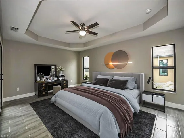 Bedroom featuring ceiling fan and a raised ceiling