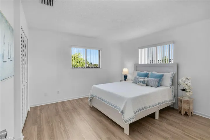 Bedroom featuring a textured ceiling, light wood-style flooring, and a closet