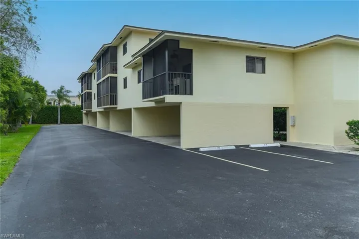 View of property exterior featuring stucco siding, uncovered parking, and a balcony
