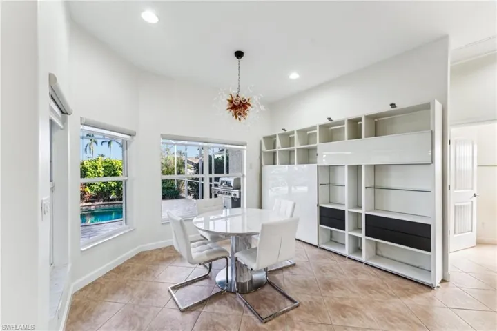 Tiled dining room featuring a high ceiling and an inviting chandelier