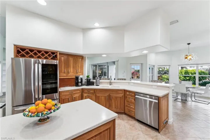 Kitchen with pendant lighting, sink, a high ceiling, light tile patterned floors, and stainless steel appliances