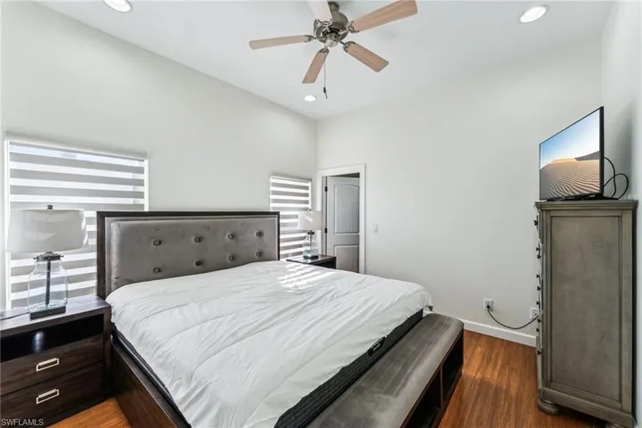Bedroom with dark hardwood / wood-style floors and ceiling fan