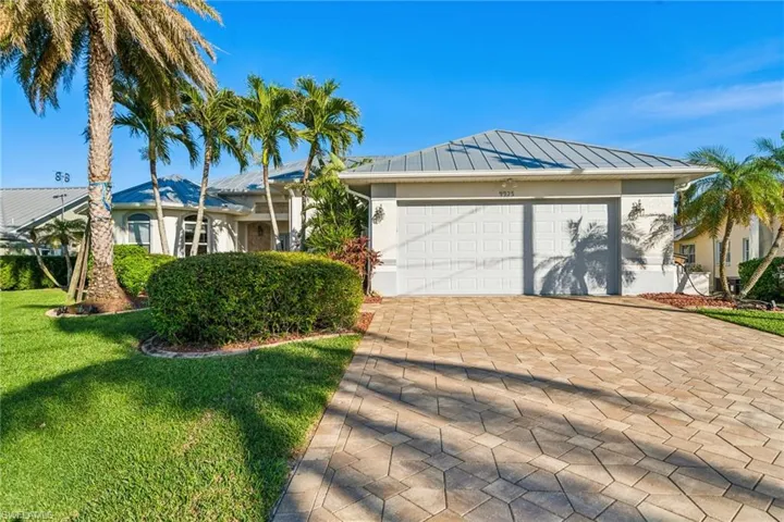 Single story home with a garage and a front lawn