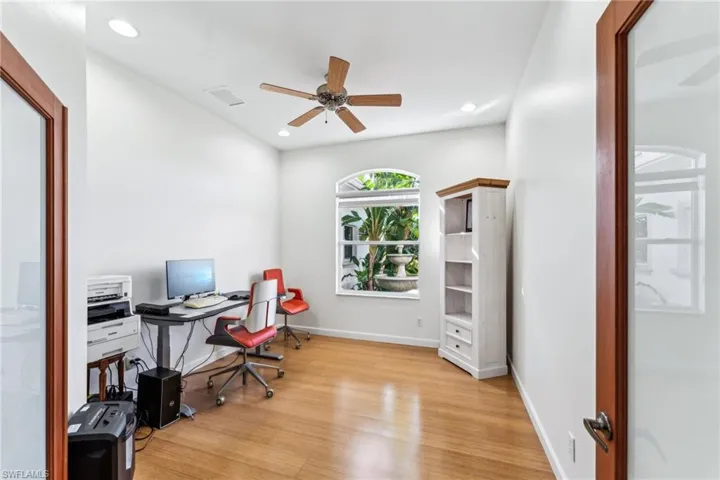 Home office with ceiling fan and light hardwood / wood-style floors