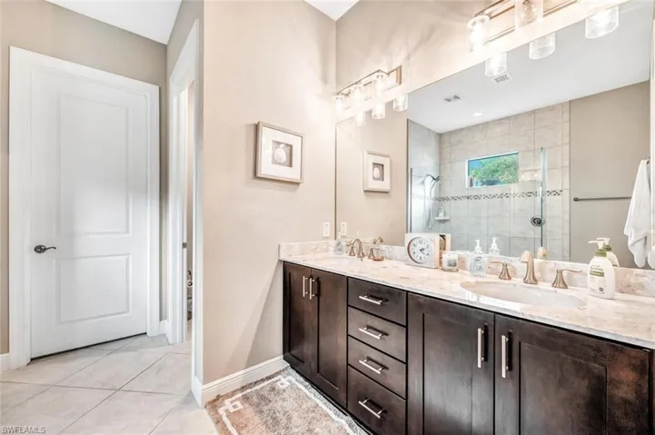 Bathroom with tile patterned flooring, walk in shower, and vanity