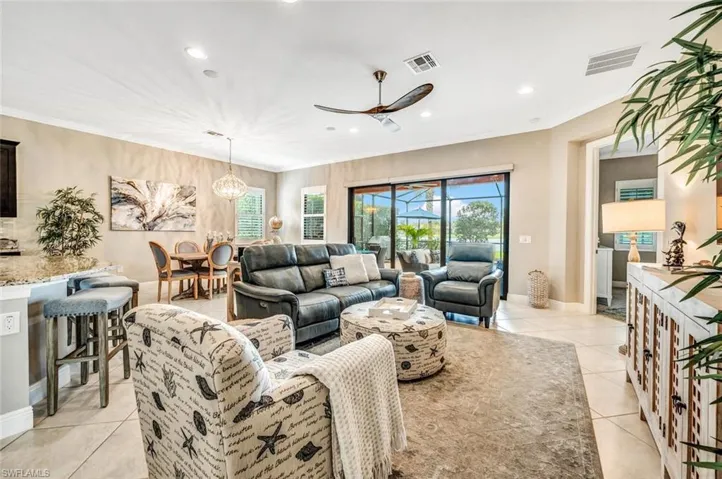 Tiled living room with crown molding, a healthy amount of sunlight, and ceiling fan