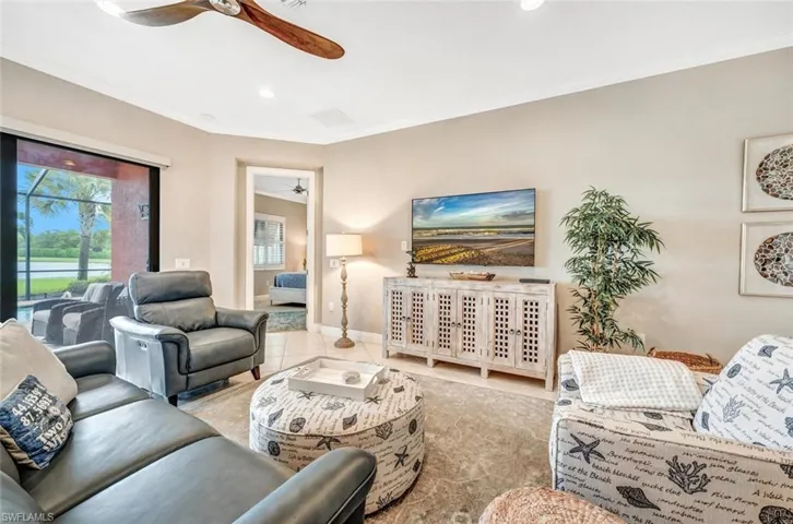 Living room with ceiling fan, crown molding, and tile patterned flooring