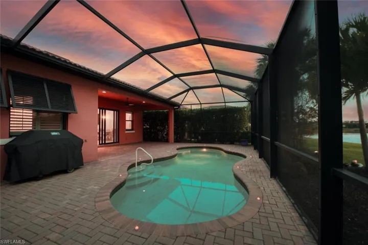Outdoor pool with a patio area, area for grilling, glass enclosure, and ceiling fan