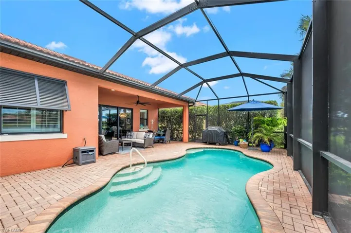 View of swimming pool featuring a lanai, a patio, ceiling fan, an outdoor hangout area, and area for grilling