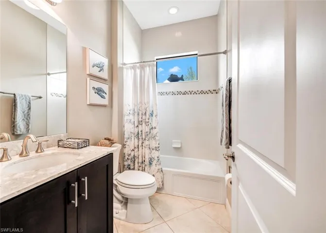 Full bathroom featuring vanity, toilet, shower / tub combo with curtain, and tile patterned floors