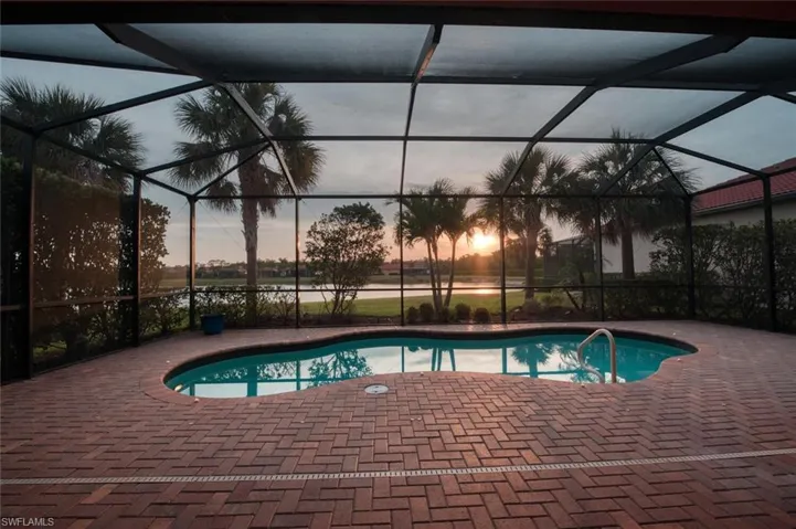 Swimming pool featuring a patio and glass enclosure