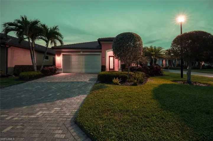 View of front of home featuring a garage, stucco siding, decorative driveway, a front lawn, and a tiled roof
