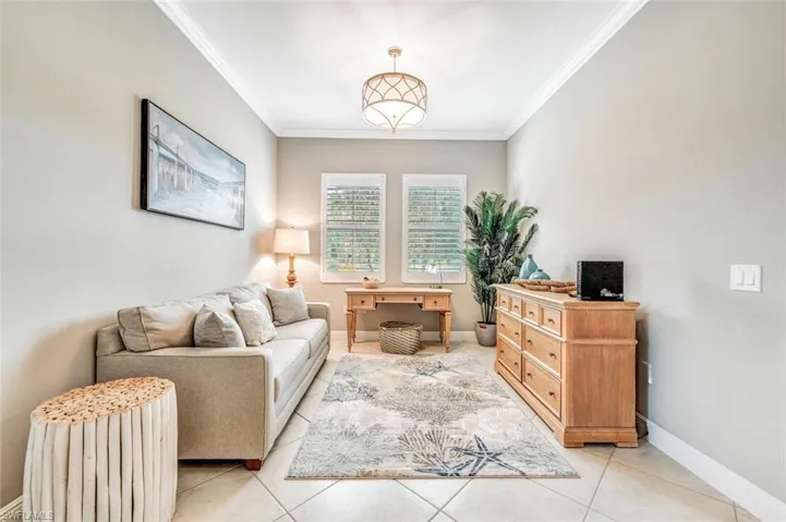 Living room featuring ornamental molding and light tile patterned flooring