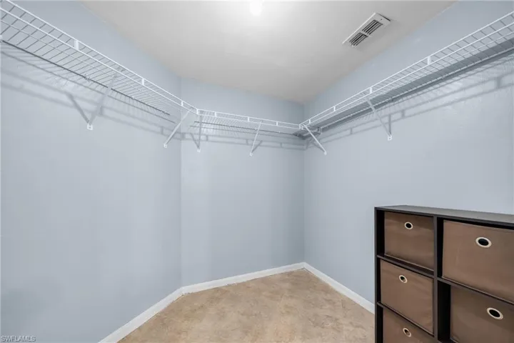 Spacious walk-in closet featuring light blue walls and wire shelving system