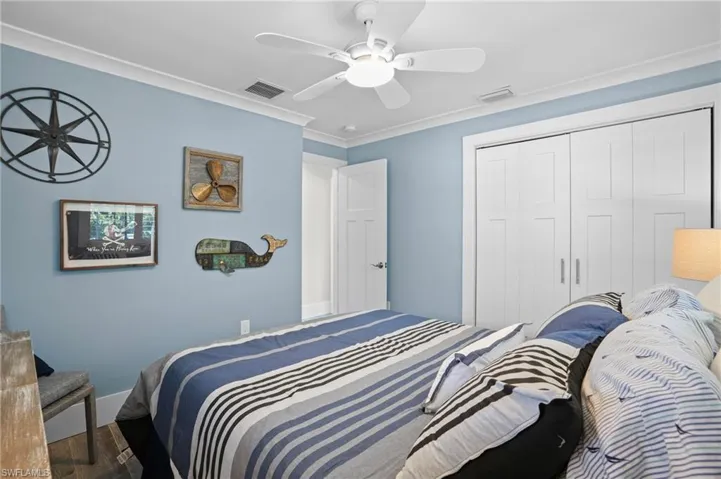 Bedroom featuring a ceiling fan, a closet, visible vents, and crown molding. Virtually Edited Image