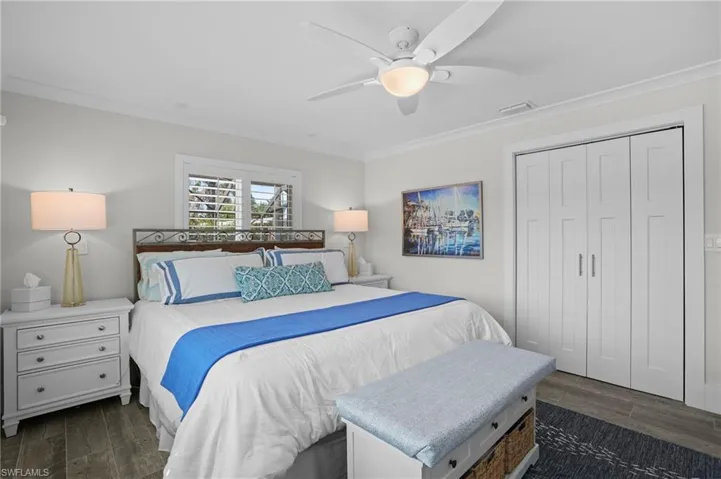 Bedroom featuring ornamental molding, dark wood-style flooring, visible vents, and a ceiling fan. Virtually Edited Image
