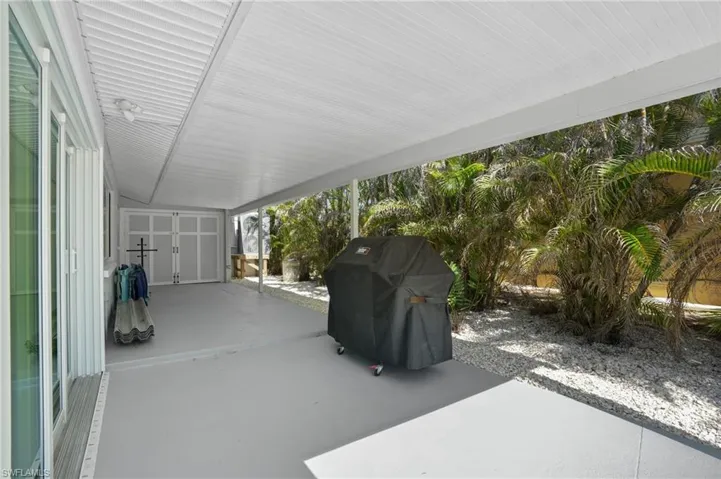 View of patio / terrace with grilling area and a carport. Virtually Edited Image