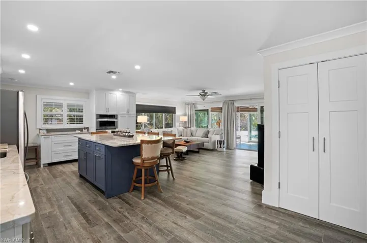 Kitchen featuring stainless steel appliances, a center island, visible vents, and white cabinetry. Virtually Edited Image