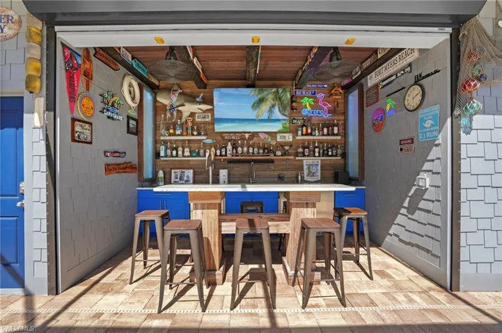 Bar featuring concrete block wall and wet bar Virtually Edited Image