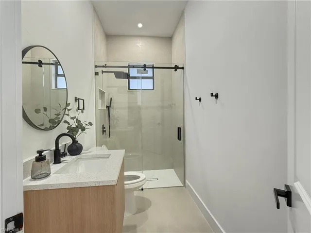 Full bath featuring vanity, a stall shower, and recessed lighting